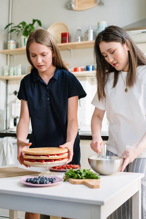 Woman in Blue Polo Shirt Holding White Ceramic Plate With Sliced Strawberries