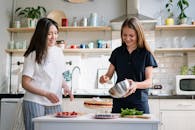 两个女人喜欢一起在明亮舒适的家庭厨房里烘焙美味的蛋糕