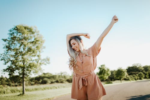 Photo of Carefree and Smiling Woman in Brown Button Front Belted Romper 