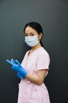 Confident healthcare worker wearing mask and gloves indoors, ready for patient care.