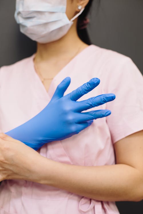 Woman in Pink Scrub Top With Blue Latex Glove and Face Mask