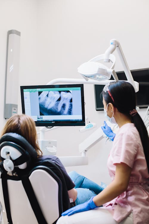 Dentist Showing Teeth of a Patient on Screen