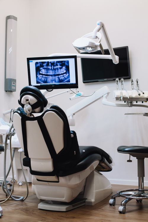 Consultório odontológico moderno com cadeira e equipamentos digitais