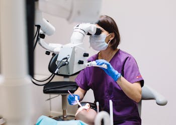 Dentista a realizar procedimento de estética dentária numa paciente