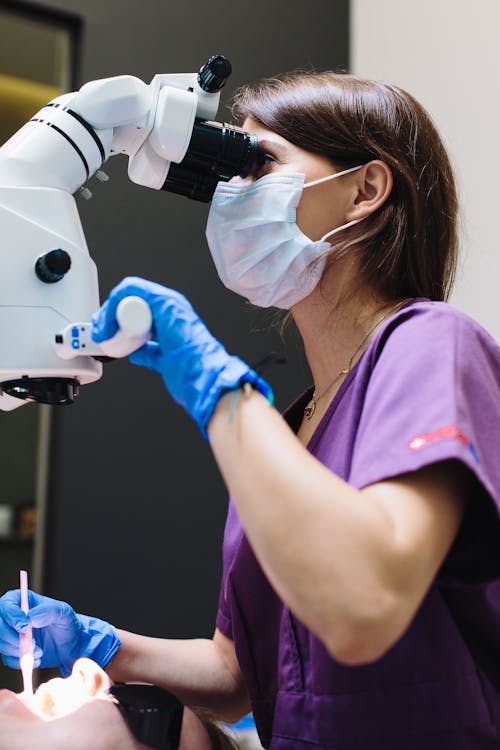 A Woman in Purple Scrub Suit Wearing Blue Mask