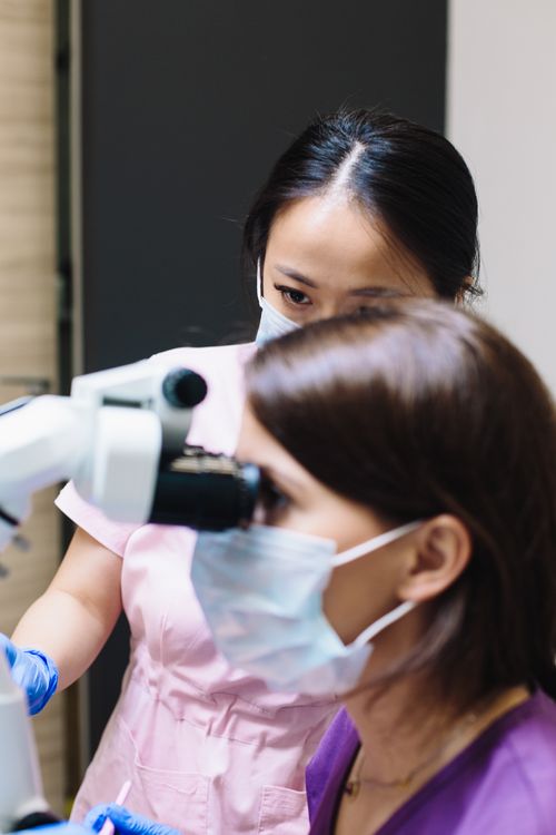 Free Two female dentists using a dental microscope in a modern clinic. Stock Photo