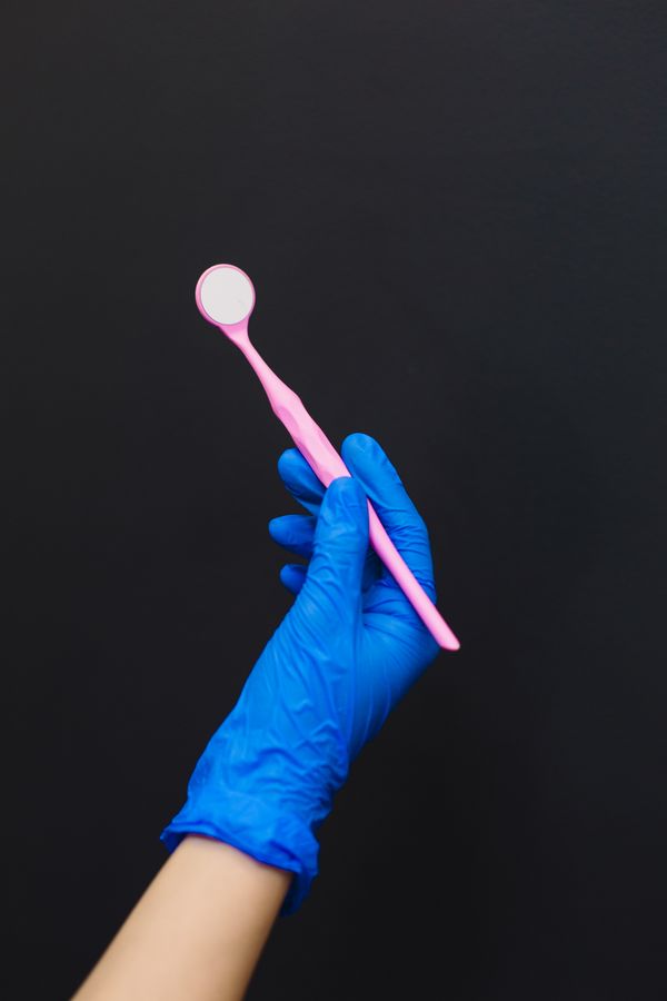Zahnärztliche Instrumente in blauen Handschuhen