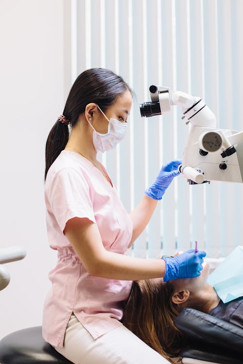 Dental Surgeon Using a Microscope During Root Canal Treatment