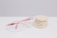 Red Framed Eyeglasses Beside White Plastic Container