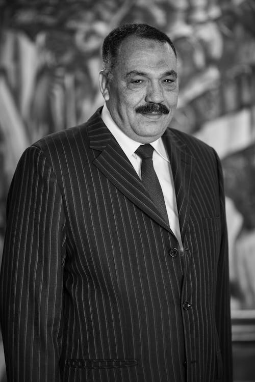 Smiling Man With Mustache Wearing a Striped Black Suit