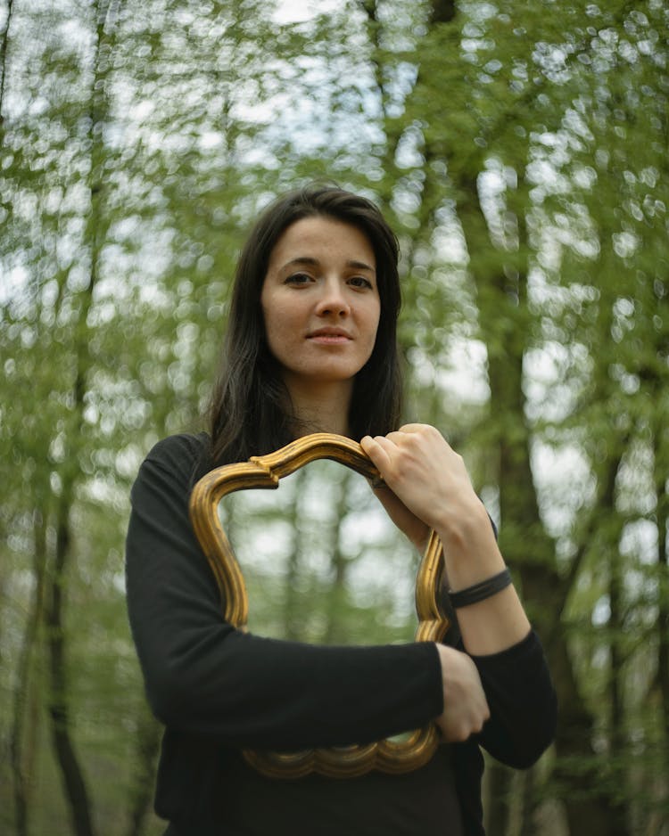 Photograph Of A Woman Holding A Mirror