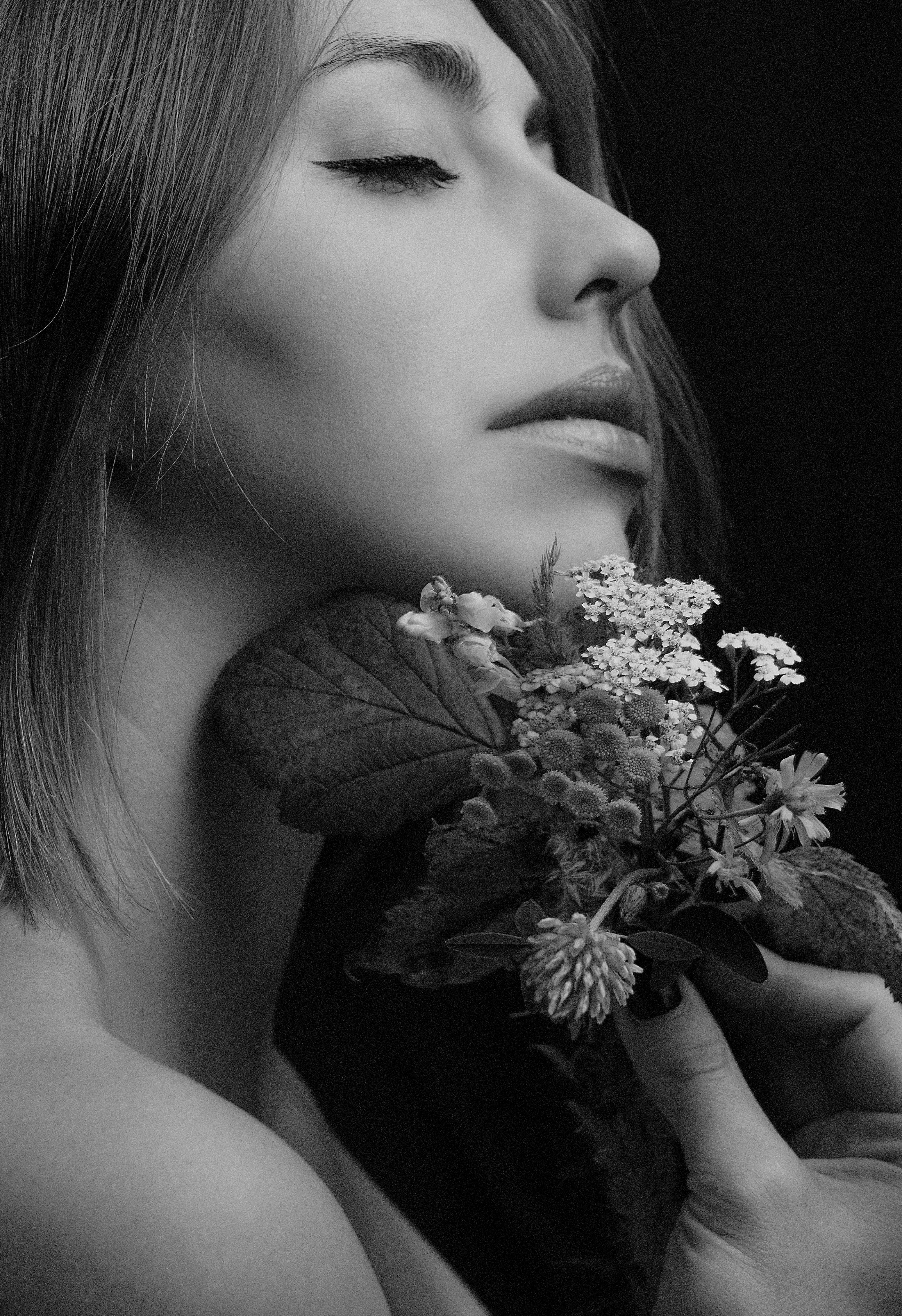 grayscale photo of woman holding flowers