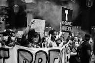 黑白照片中，都灵的抗议者们戴着口罩，举着标语牌