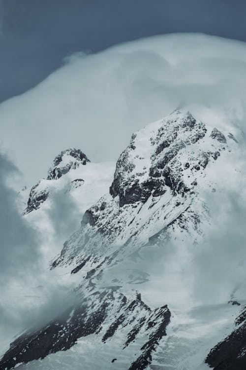 Snow Covered Mountain Under a Cloudy Sky