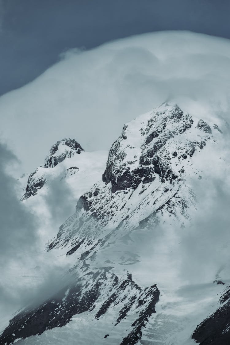 Snow Covered Mountain Under A Cloudy Sky