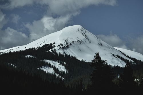 Free Majestic snowy mountain peak under a cloudy sky, captured in a serene winter landscape. Stock Photo