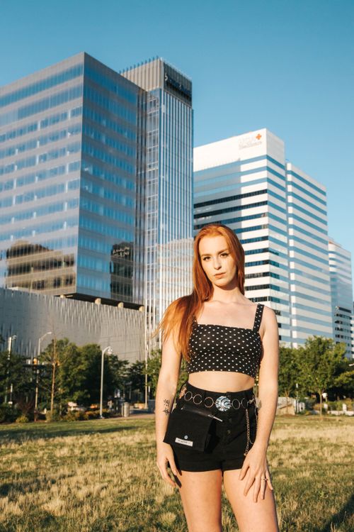 Free Stylish woman in cityscape with modern buildings, enjoying a sunny day. Stock Photo