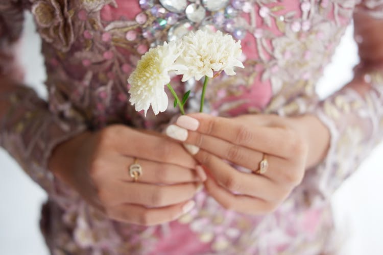 Person In Beaded Dress Holding White And Yellow Dahlia Flowers