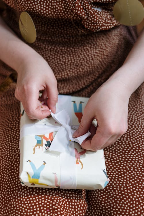 Person Holding White and Yellow Floral Paper