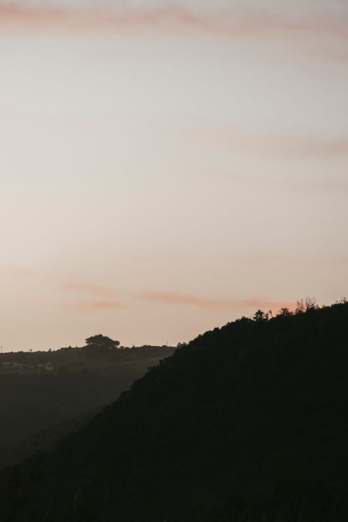 Free Tranquil hillside scene capturing the last light of twilight, perfect for peaceful and calming design needs. Stock Photo