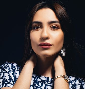 Elegant portrait of a woman with jewelry, taken in a studio setting.