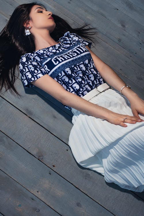 Woman in White and Blue Top Lying on the Floor