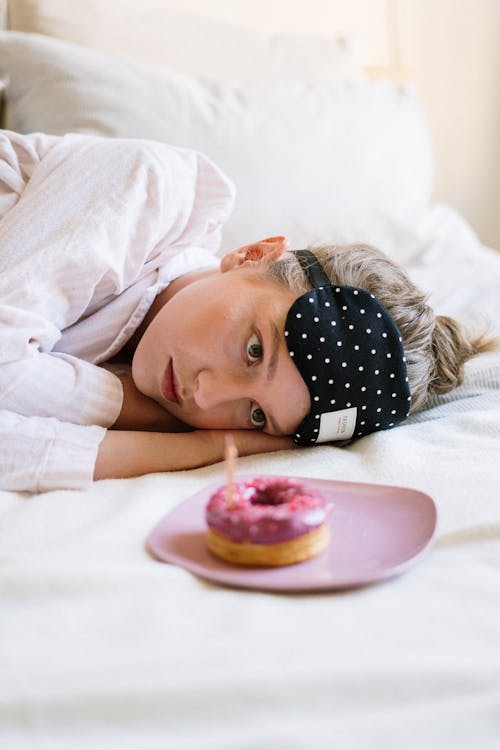 Free Woman in White Long Sleeve Shirt Lying on Bed Stock Photo