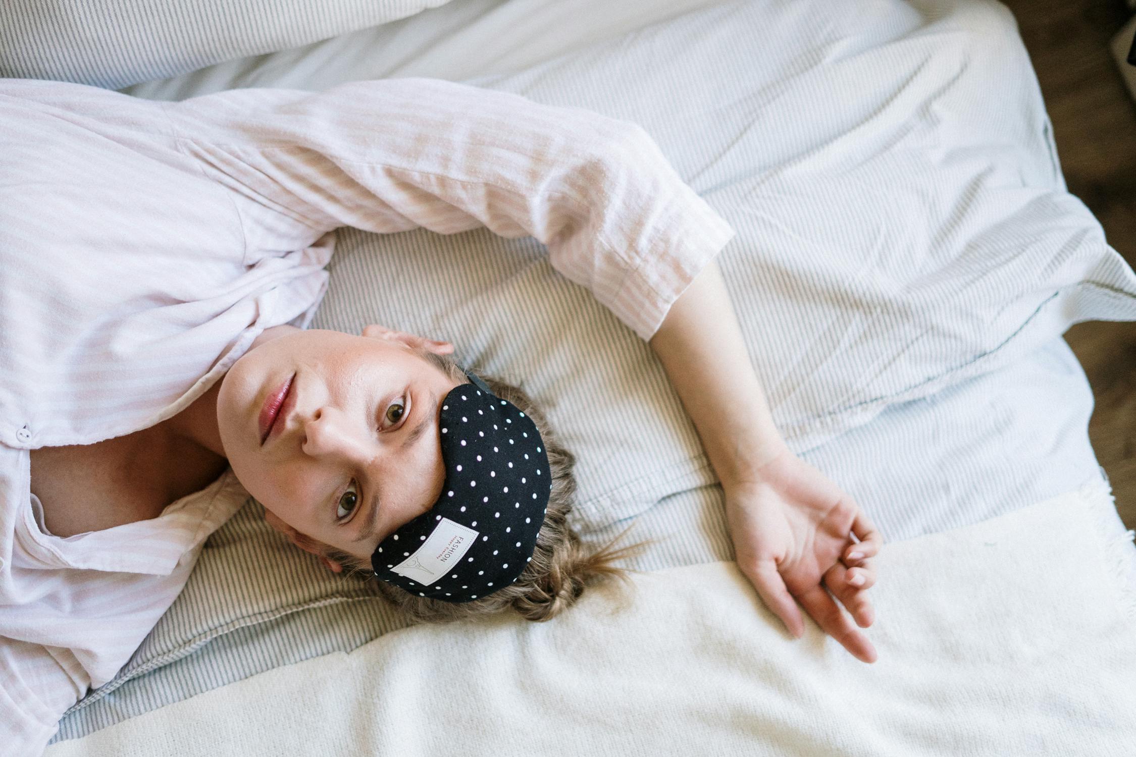 woman laying in bed with eye mask
