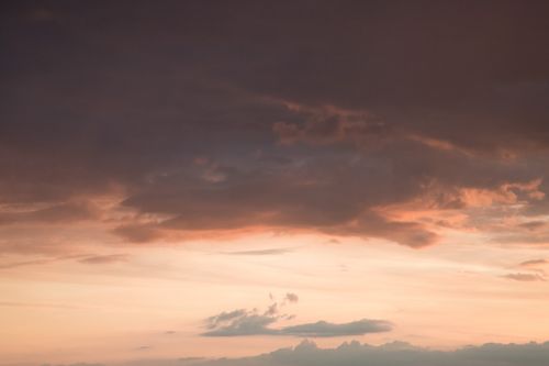 Free From below of fluffy gray clouds floating on colorful orange sky at sundown Stock Photo