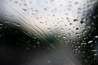 雨天玻璃窗上雨滴形成的抽象图案特写图