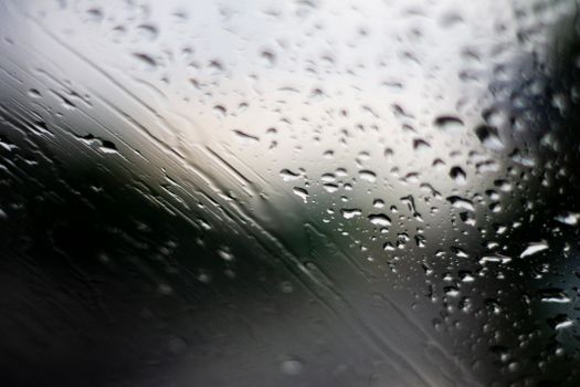 雨天玻璃窗上雨滴形成的抽象图案特写图