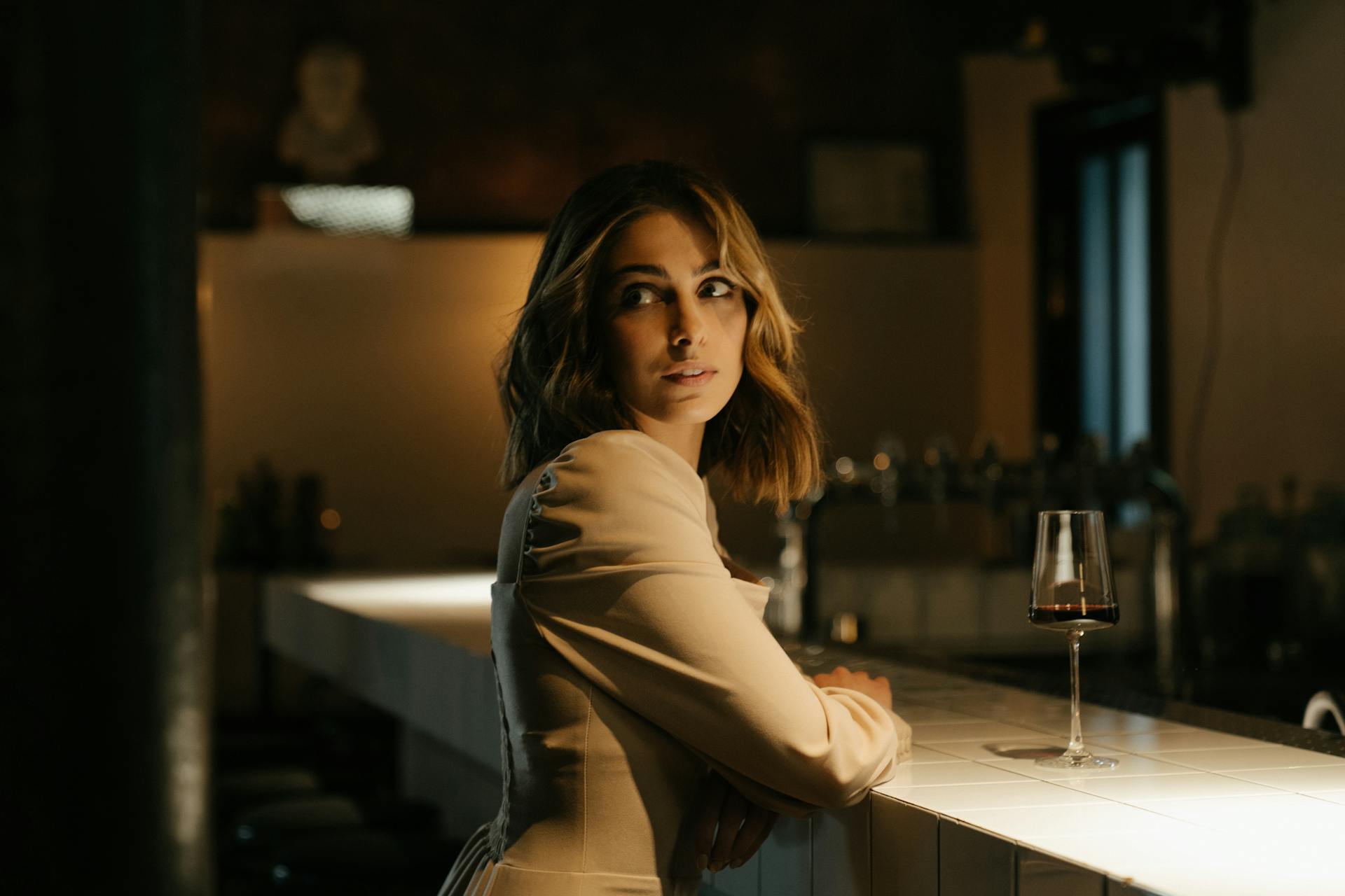 Woman in Gray Long Sleeve Shirt Sitting on Bar Seat