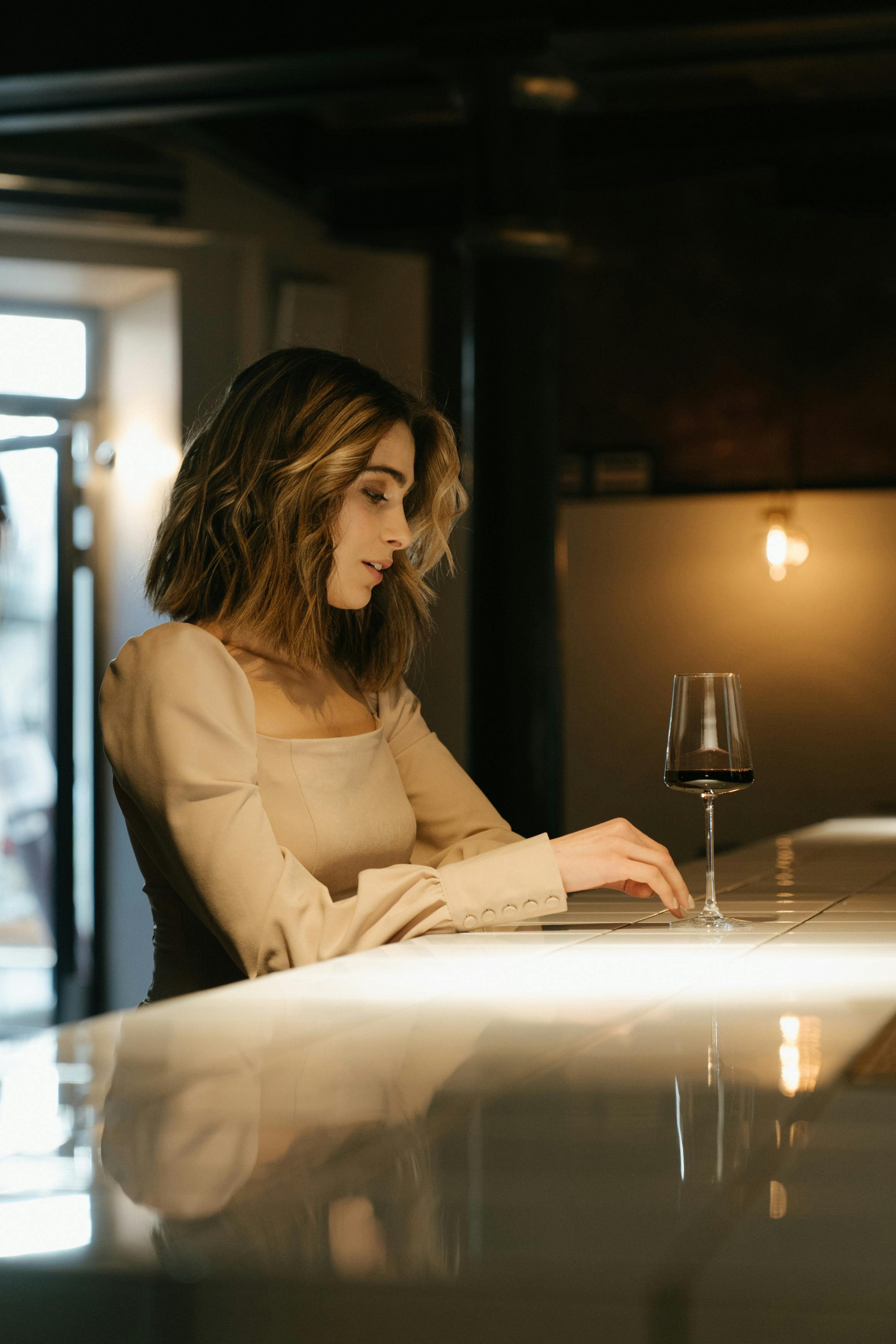 woman in brown long sleeve shirt sitting by the table