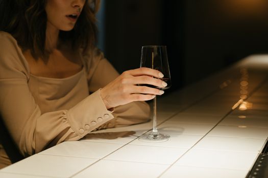 酒吧里，一名身着优雅连衣裙的女子手持酒杯，营造出一种喜怒无常的氛围