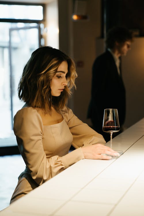 Woman in Brown Long Sleeve Shirt Sitting at the Table
