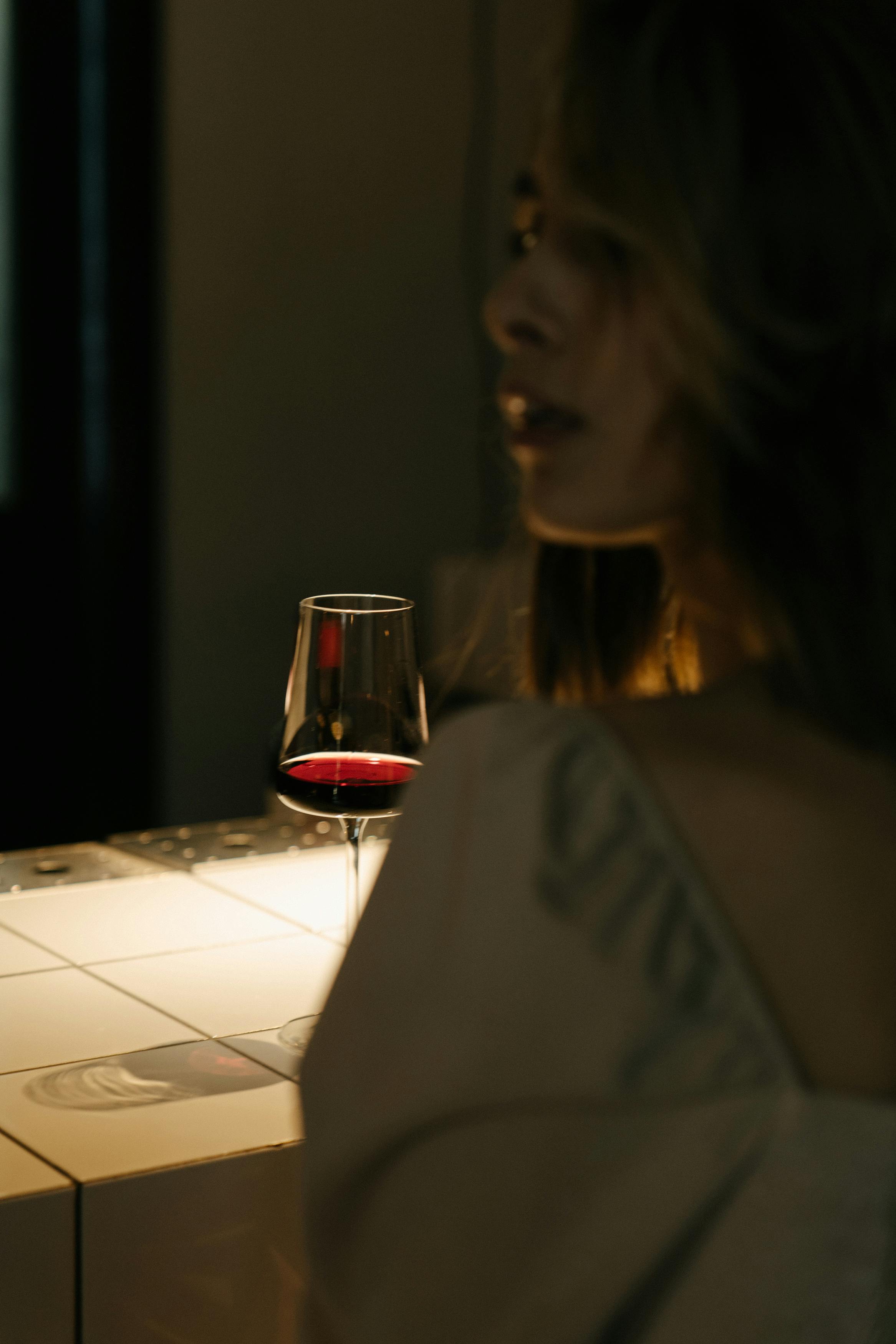 woman in white shirt holding clear drinking glass