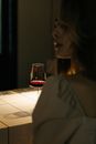 酒吧里，一名女子端着红酒，营造出优雅而略带忧郁的氛围