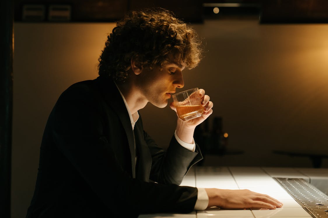 Man in Black Suit Drinking Beer