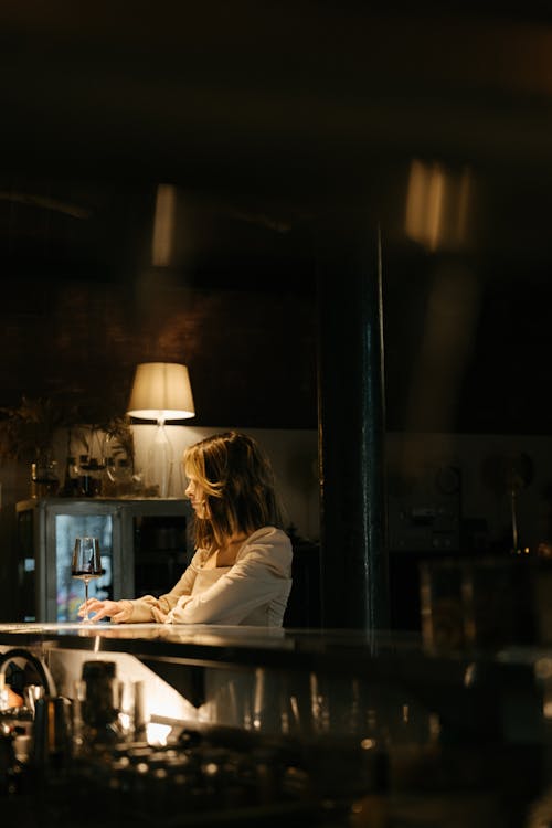 Woman in White Long Sleeve Shirt Sitting on Chair