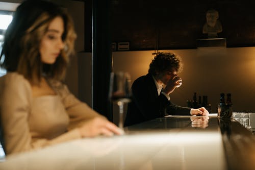 Man in Black Suit Jacket Sitting Beside Woman in White Dress