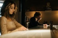 一名卷发女子和一名男子在优雅的酒吧环境中享用饮料