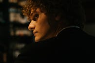 酒吧里，一名卷发男子的侧面轮廓特写