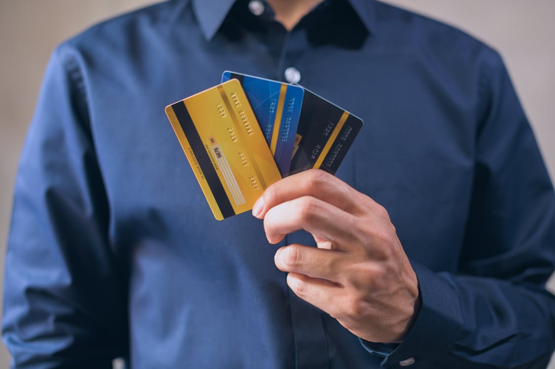 Free Man in Blue Dress Shirt Holding Three Credit Cards Stock Photo