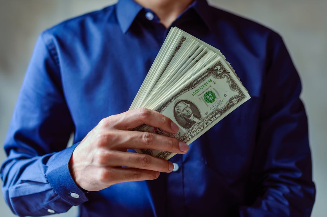 Free Person Holding US Dollar Bills Stock Photo