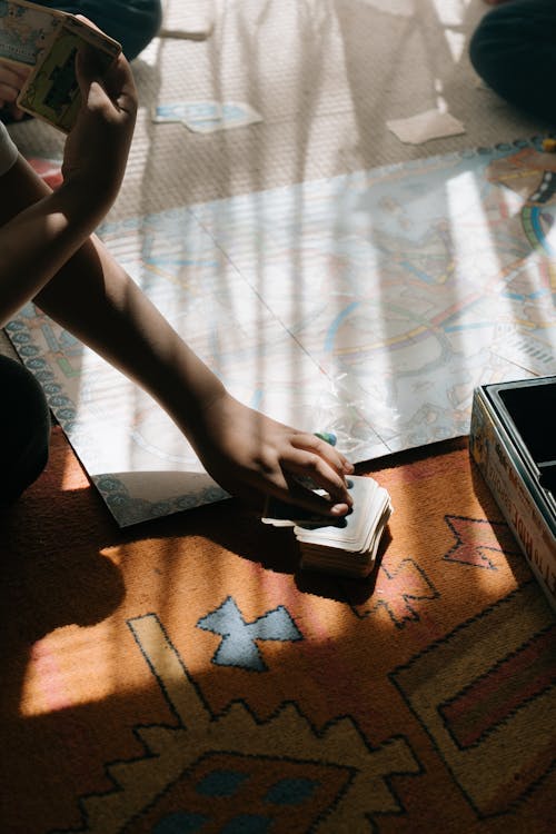 Person Holding Black Smartphone on Brown Wooden Table