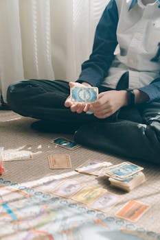 A child in casual clothing engaging in a strategic card game indoors, focused on gameplay.