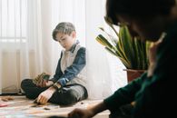 孩子们在室内自然光下玩桌面纸牌游戏，既能休闲放松，又能锻炼策略能力