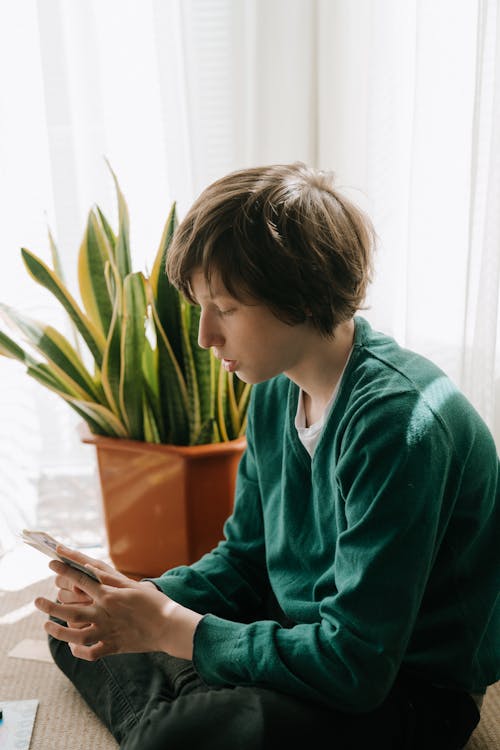 Boy in Green Sweater Holding Pen