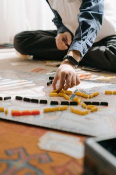 一个孩子正坐在室内，专心地玩着彩色棋子的策略棋盘游戏