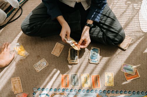 Free A child engages in a fun board game indoors, surrounded by cards and game pieces. Stock Photo
